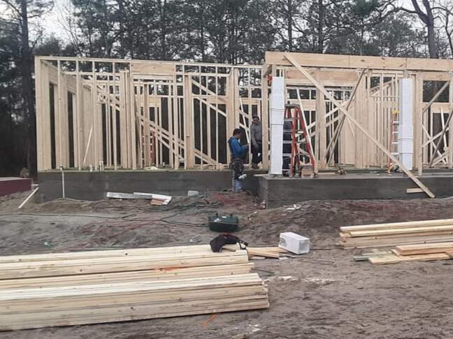 someone using a nail gun to nail roofing shingles